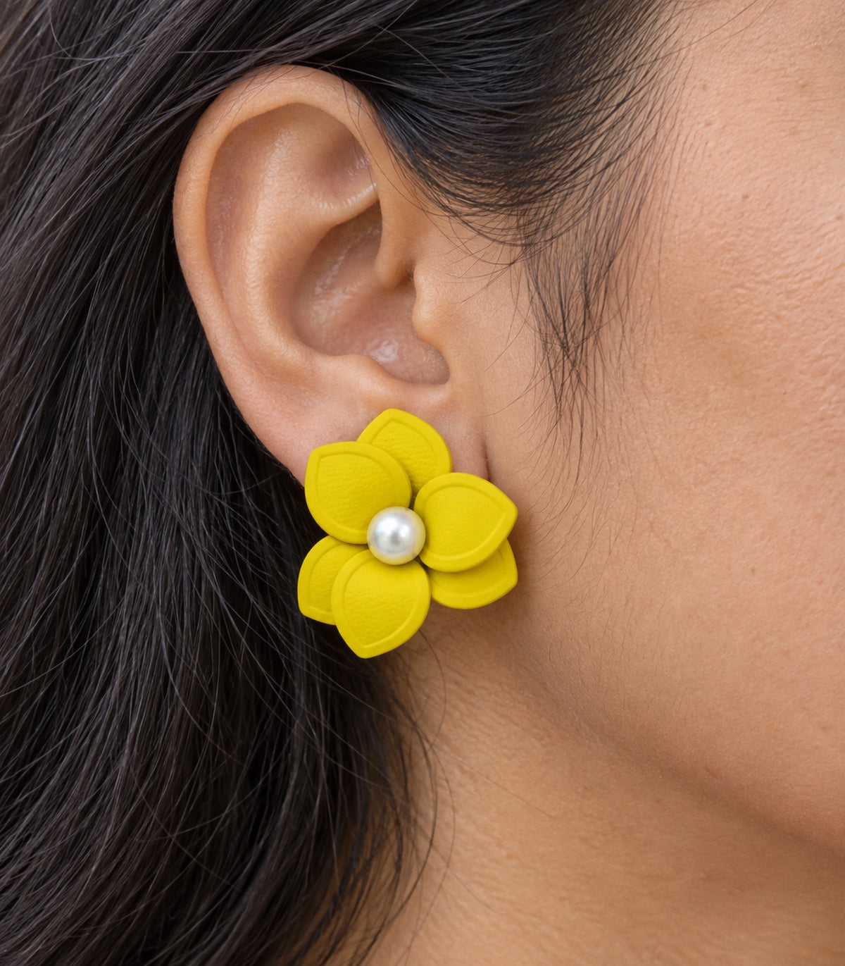 JIMIKI Yellow Triple Petal Pearl Flower Stud Earrings - layered petals and pearl-style centre worn close-up #color_yellow